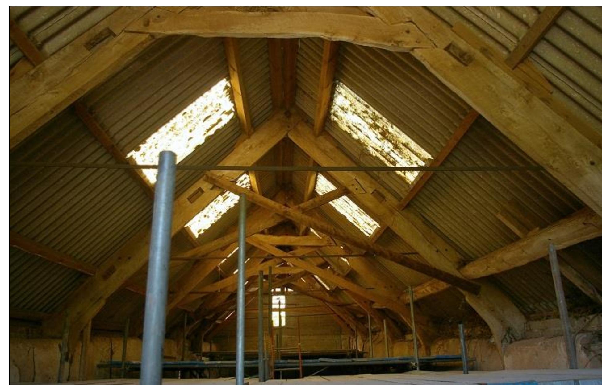 FIGURE 10: THE ROOF OVER B1.1 IS OF FIVE JOINTED CRUCK TRUSSES; SOME OF THESE HAVE LATER SCISSOR BRACES ATTACHED; THERE IS ONE ADDITIONAL MODERN A-FRAME TO THE WEST END. 
