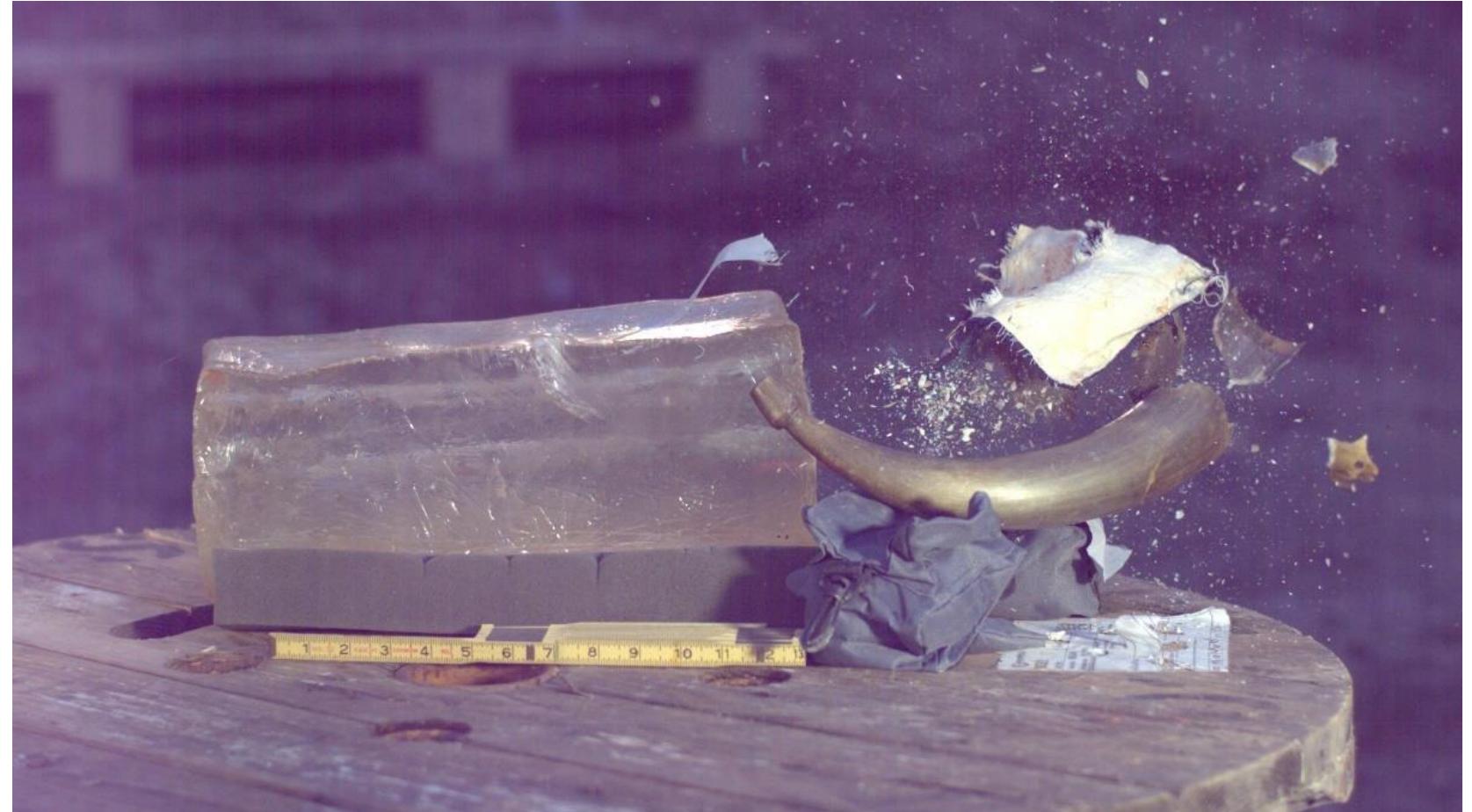 Figure 44. Powder horn 2 in the process of shattering after being hit by the ball. Note the cloth flying through the air, fragments of horn being dispersed, and the end plug being blown out of the horn. 