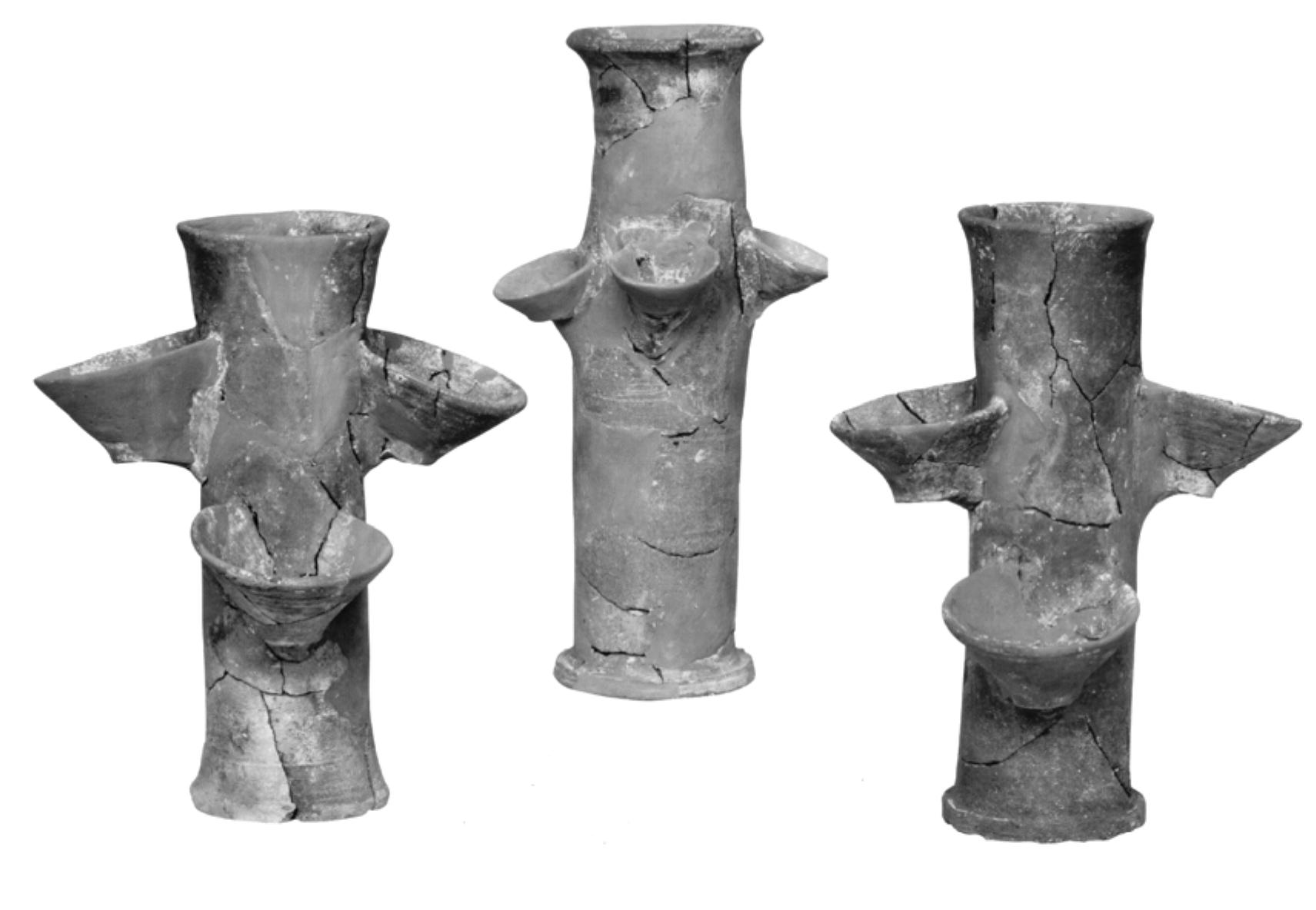 The three “cylinders” or “tubes” (height 28 cm and exterior diameter of base 9.6 cm) (No 4, 5, 6 of fig.16; fig. 23) found in the “snake room”, have two pairs of cups. symmetrically attached to their sides. Evans suggested that these cups were “made tc contain some kind of drink offering to snakes” and labelled them “cylindrical snake vessels”!®?. We believe, however, that the cups were used as receptors of the overflowec liquid content of the tube. More specifically, we propose that these vessels served as wax  extractors from the combs once honey was extracted first'**,  Fig. 23. Cylindrical vessel from the “snake room” of Knossos (photo Herakleion Museum) 