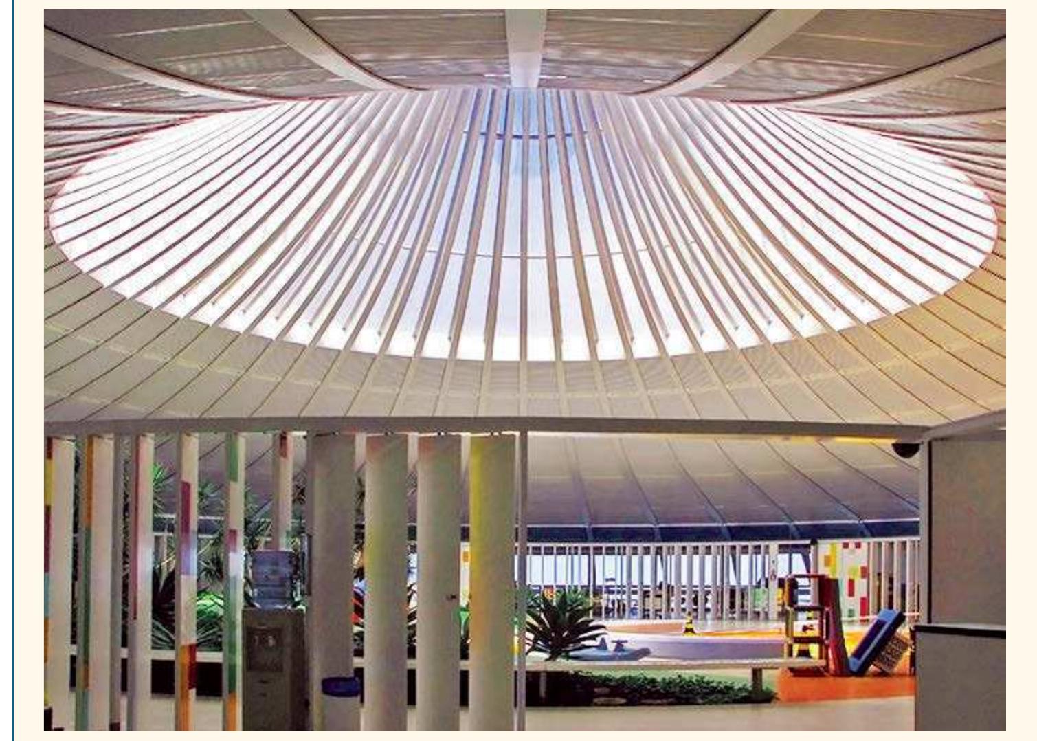 The central ring of the roof offers daylight and views to the sky. Athos Bulcao designed the operable and colorful panels that decorate the hydrotherapy area, indoor playground, and central garden area, with th  refectory, restrooms, offices, and therapy room adjacent. (Photograph courtesy of the personal archive o1 Hugo Segawa. All rights reserved.) 