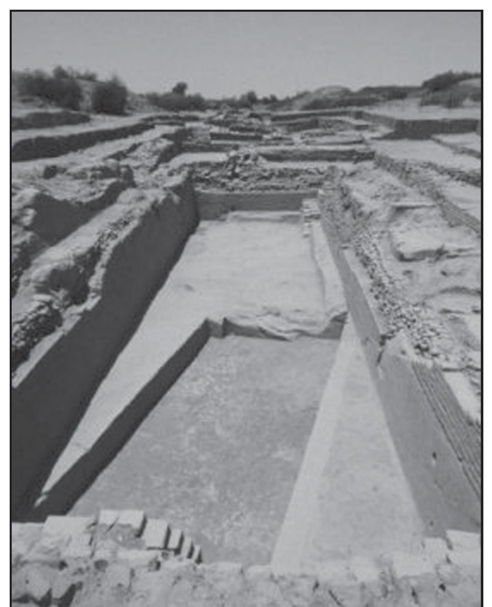 Fig. 37. One of the water tanks excavated at Dholavira.  regular living, was 7 m. The castle had a fortification whose extant height is 9 m and width 15.5 m. The fortification was steeply battered and had gates on all sides, two of which have been excavated on the north and the east. The eastern wall had two gates, thus making the total number of ‘castle’ gates five. The major excavated eastern gateway was fronted by a terrace, from which the entry passage led to a wide corridor flanked by a chamber on the south. The corridor led to a flight of stairs up the wall. The level of the flanking chamber is said to be higher than the level of the corridor and its open front was supported, as seen on the plan, by three pilasters with polished limestone blocks as base. The stairs led to an upper terrace between two bastions, and from there another series of steps led to the ground level. Between the entry passage and the inner corridor there 