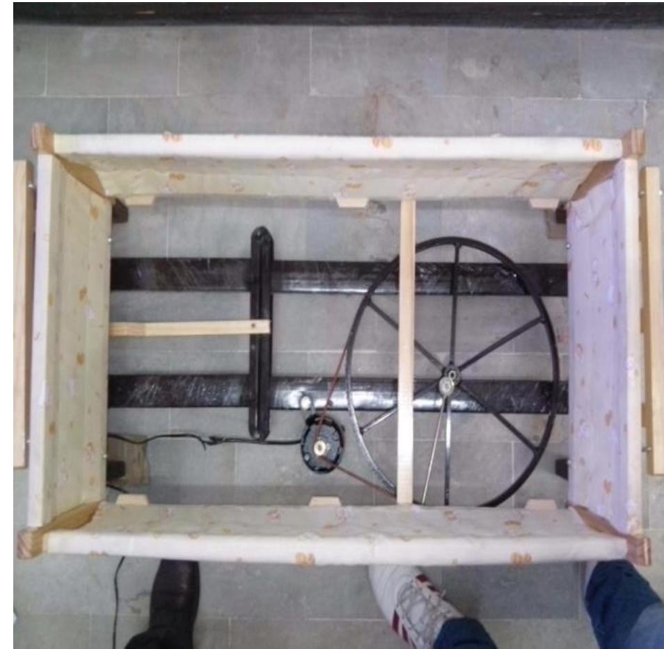 As shown in Fig 3 and Fig 4, baby bassinet is made of wood with dimensions: length 90cm, height 25cm and breadth 49cm. Bassinet is mounted on mechanical system which consists of base frame, motor, connecting rod, roller and a belt. Motor has a small drive roller with diameter 2cm. The motor drives larger drive roller with diameter 40cm which reduces rpm and gets desired torque. The larger wheel is connected to base of bassinet with connecting rod. The mechanical system has low wear and tear and requires less maintenance.  Fig 3: Top view of cradle design 